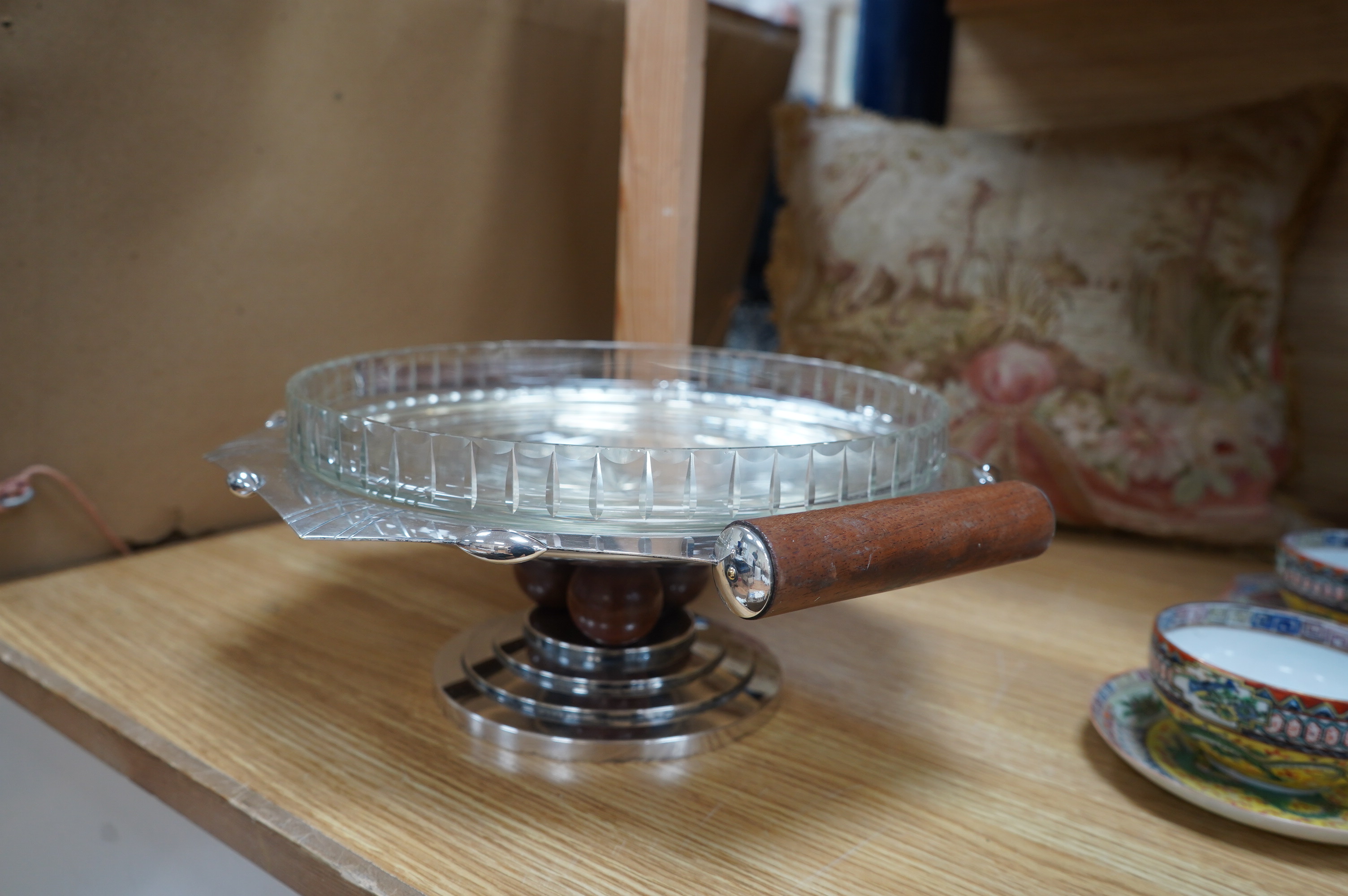 A French Art Deco silver plated and glass comport, with wood handles, set on three wooden spheres above a stepped plated base, 36cm wide, 13.5cm high. Condition - good